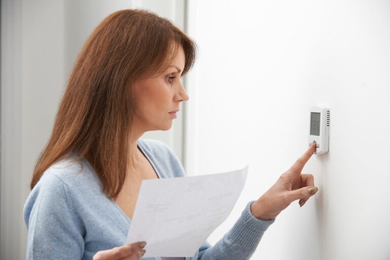 Woman Adjusting AC Thermostat